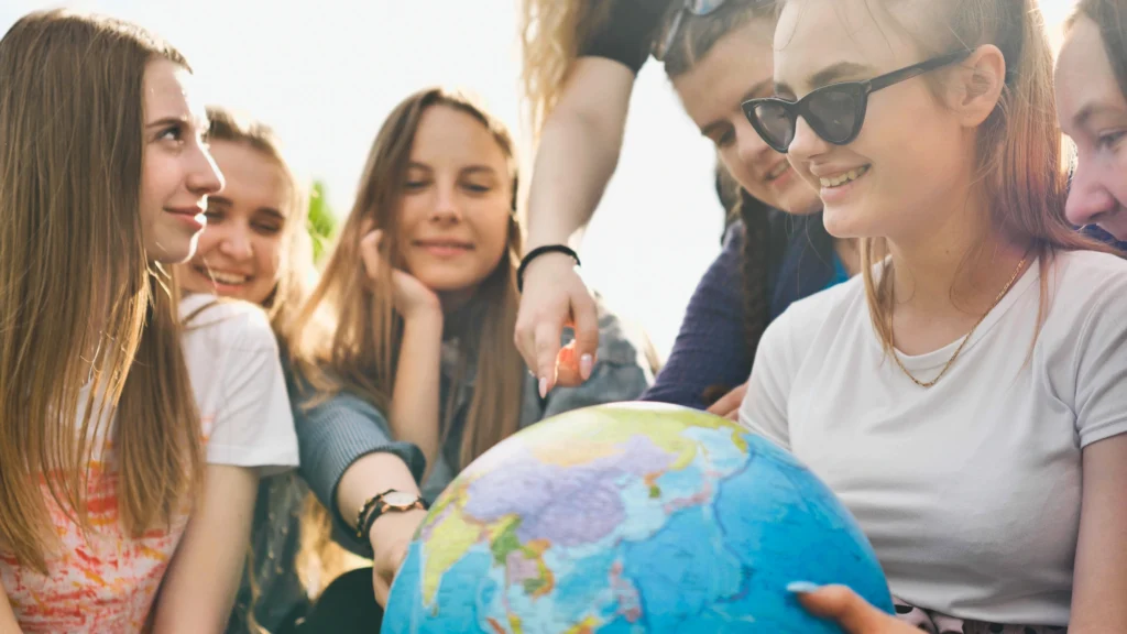 Students exploring a globe together while learning about the world