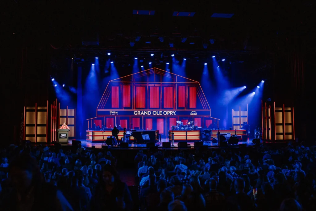 Packed audience watching a performance on the Grand Ole Opry stage