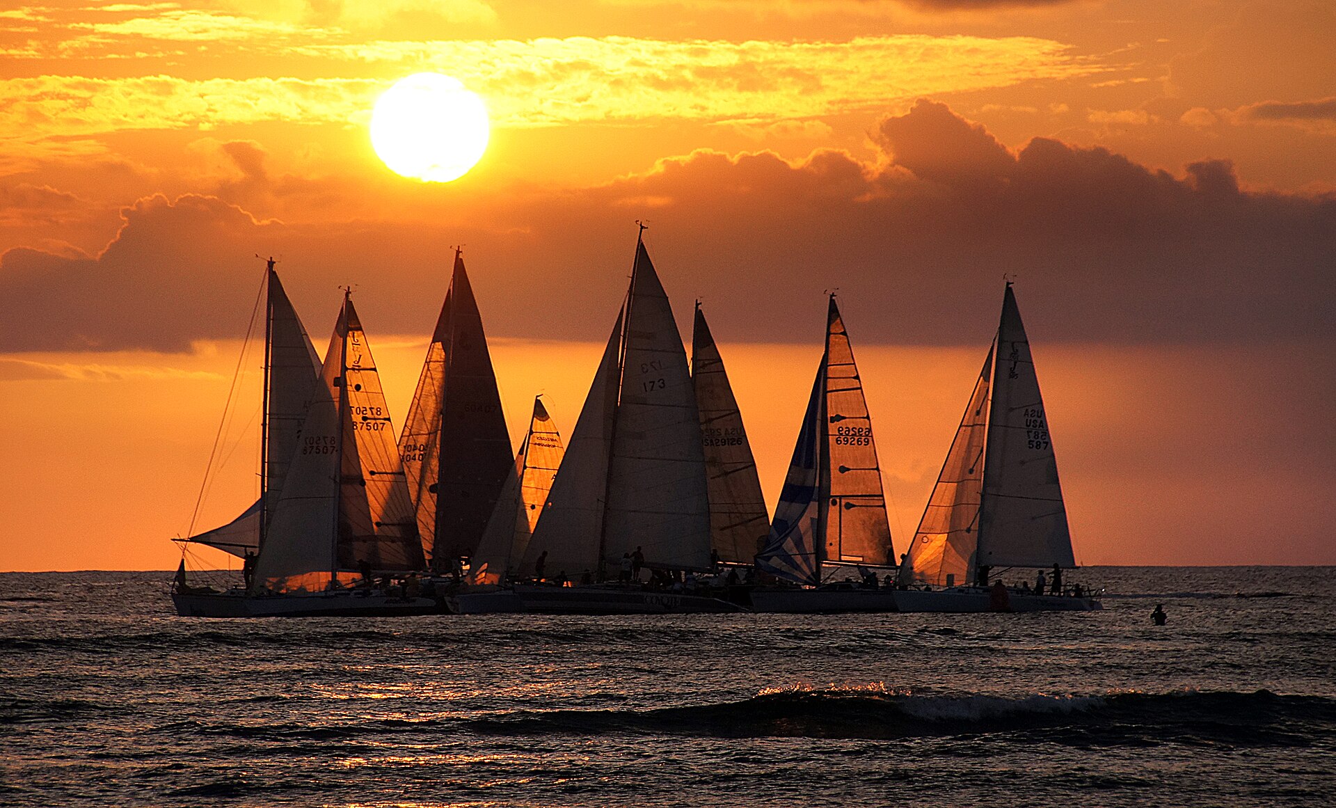 Sailboats on the water off Waikīkī at sunset